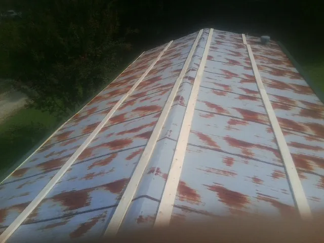 Rusted metal roof panels with new wood purlins before replacement — Storm Damage Roof Repair in Round O by Roofing Brothers