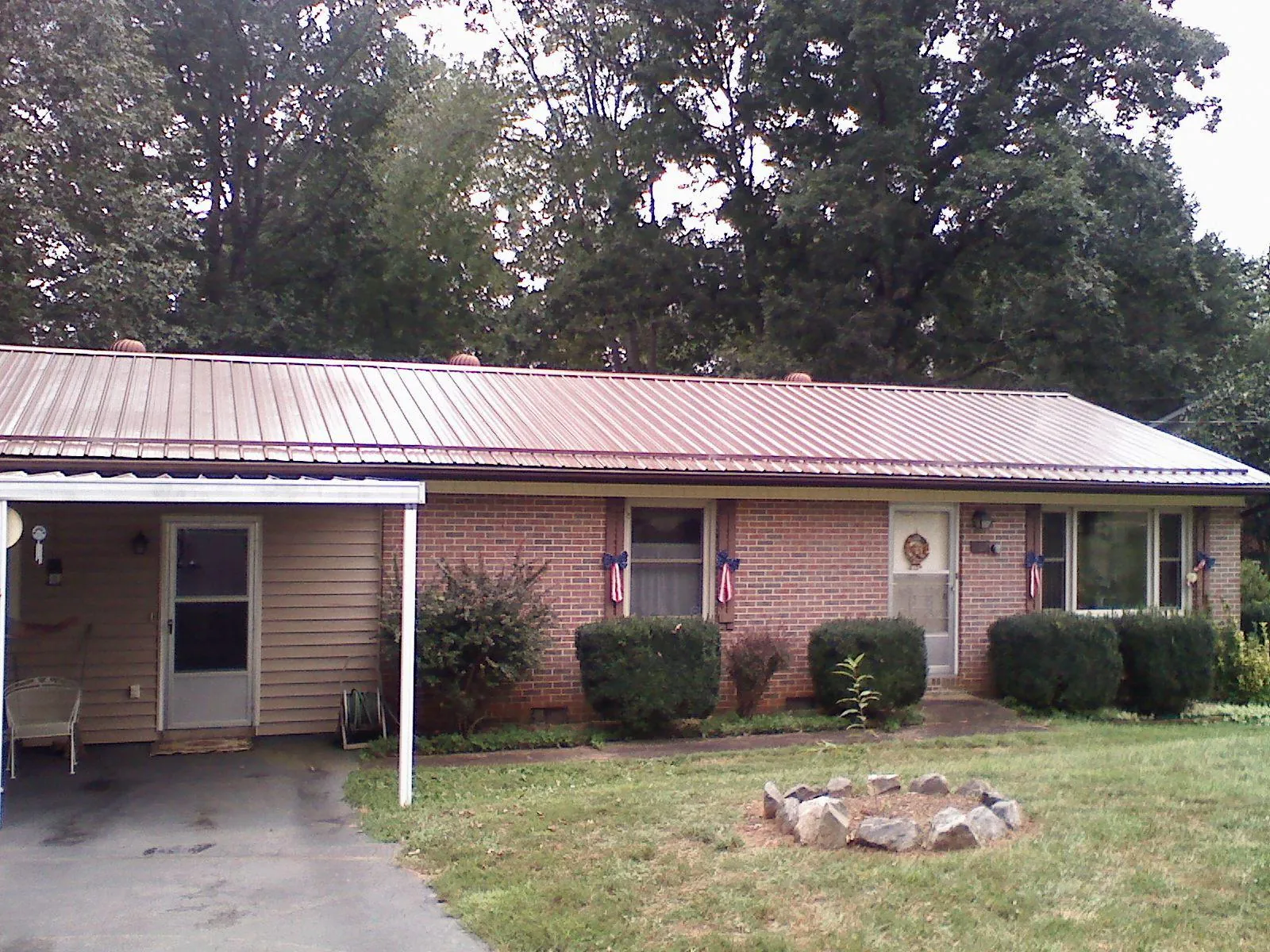 Bronze metal roof and carport on a brick ranch home — Roof Repair work by our crew in Round O