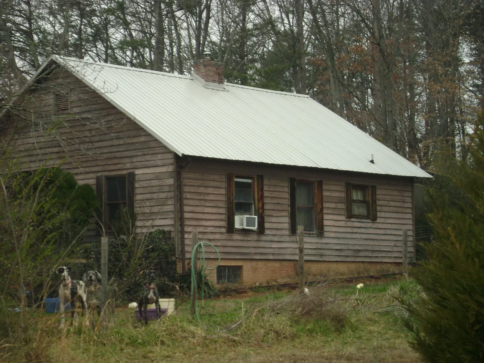 White metal roof on an old wood sided farmhouse, from a Metal Roof Installation job in Round O